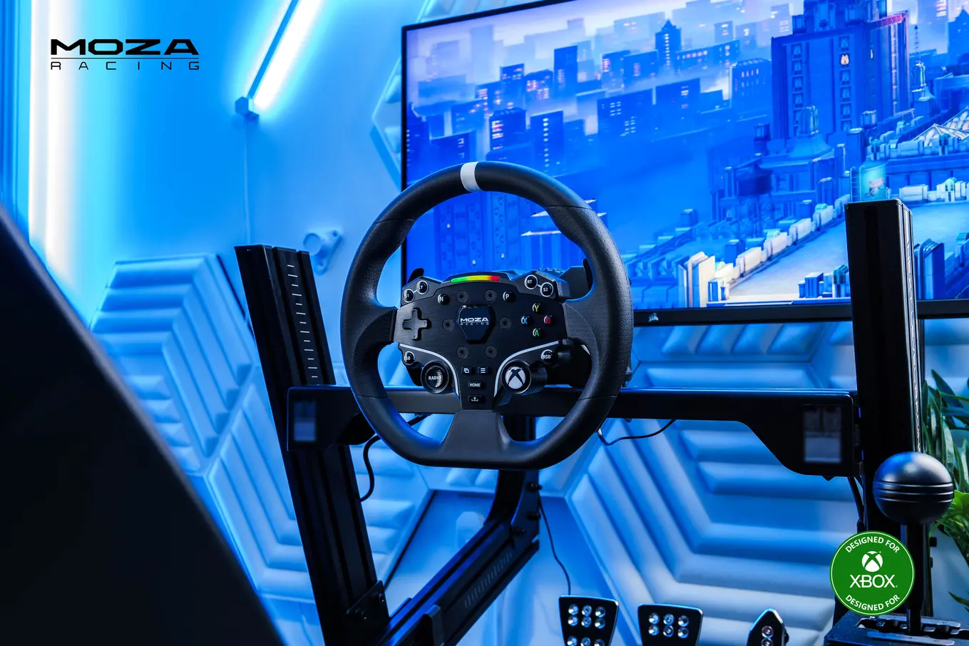 MOZA ESX volant monté dans un cockpit de sim racing en aluminium avec des pédales MOZA, un levier de vitesses et un moniteur, avec le badge Designed for Xbox